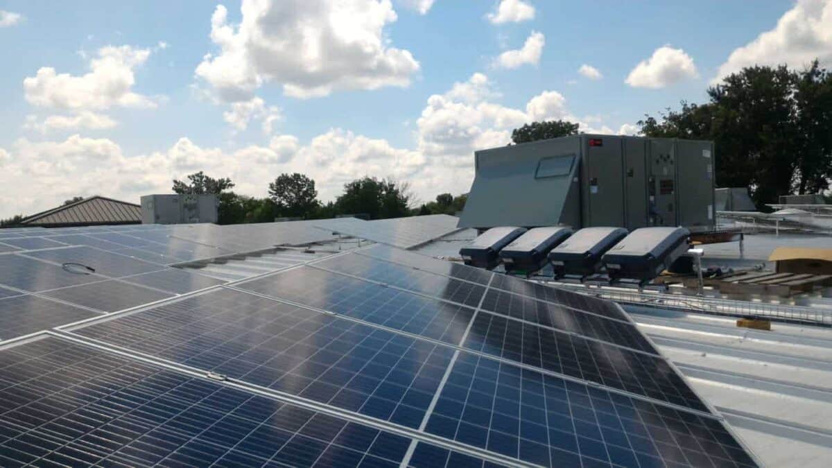 solar panels on rooftop of office building with battery units installed nearby